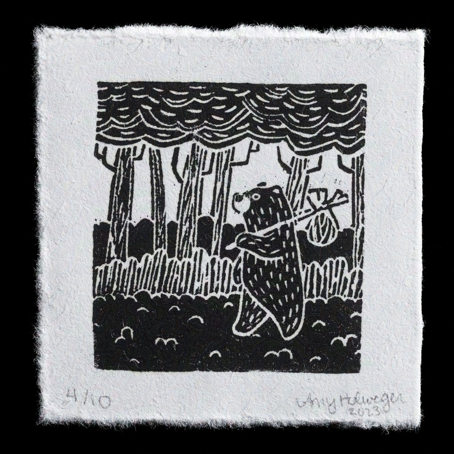 This linocut print, "The Wanderer" by Amy Holweger, showcases a serene forest scene with trees and foliage. The monochromatic color palette features a range of grays, creating a subtle contrast between the different elements.