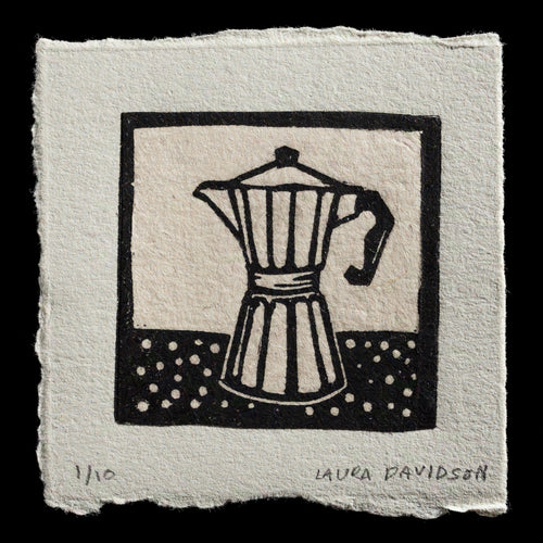 This captivating linocut print, titled 'Moka Pot,' showcases a stylized depiction of a Moka pot against a square background featuring polka dots in black and white hues. The artist's name, Laura Davidson, is discreetly inscribed at the bottom right corner. The overall effect of the print is one of simplicity and elegance, with clean lines and bold contrasts creating a visually striking image.