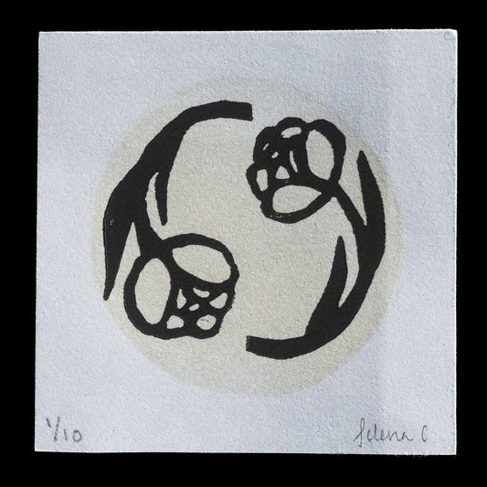 The image depicts an artwork titled "Two Peas in a Pod" by Selena Contreras, executed through the technique of linocut. The print showcases two peas enclosed within a pod-like structure, rendered in black ink against a white background. This minimalist design emphasizes simplicity and elegance, with subtle nuances in the line work suggesting a high level of craftsmanship.