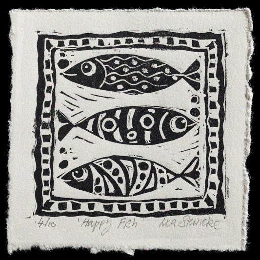 This linocut print, titled "Happy Fish" by Lisa Steincke, features three stylized fish in black ink on a white background. The fish are depicted in various positions within a rectangular border, showcasing the artist's unique style and technique.