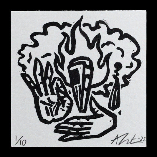 The image features a linocut print titled "Milagro" by Ashley Trist�n. The artwork showcases a stylized depiction of a hand grasping a flame, rendered in black ink on white paper.