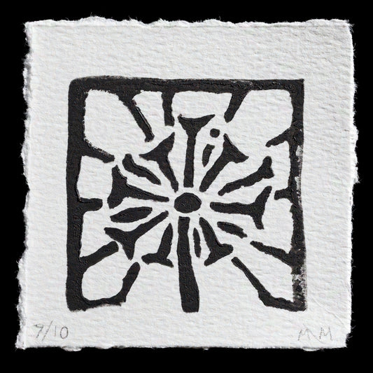 This print, "Dandelion" by Maria N Mills, showcases a linocut technique that brings to life the intricate details of a dandelion flower. A square border frames the delicate petals, while the background remains a crisp white, allowing the black lines and shapes to take center stage. The artist's signature is discreetly placed in the bottom-right corner.