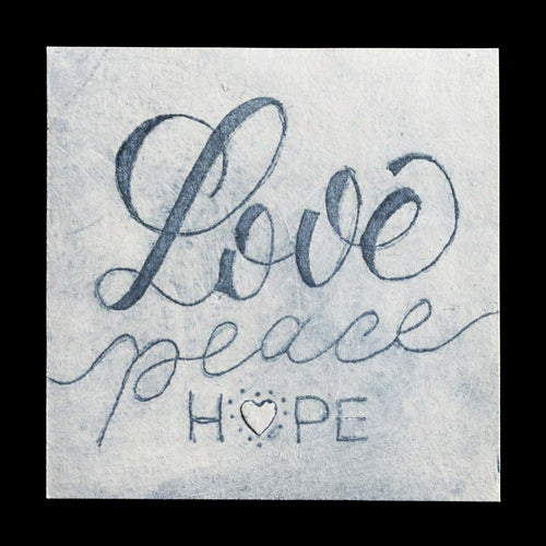 This captivating print titled 'Love � Peace � Hope' by Katja Haas showcases a harmonious blend of intaglio and drypoint techniques. The artwork features a soothing color palette of gray, white, and black, with a striking contrast between the dark background and light text. The elegant script font adds an air of sophistication to the piece, while the TetraPak material contributes a unique texture.