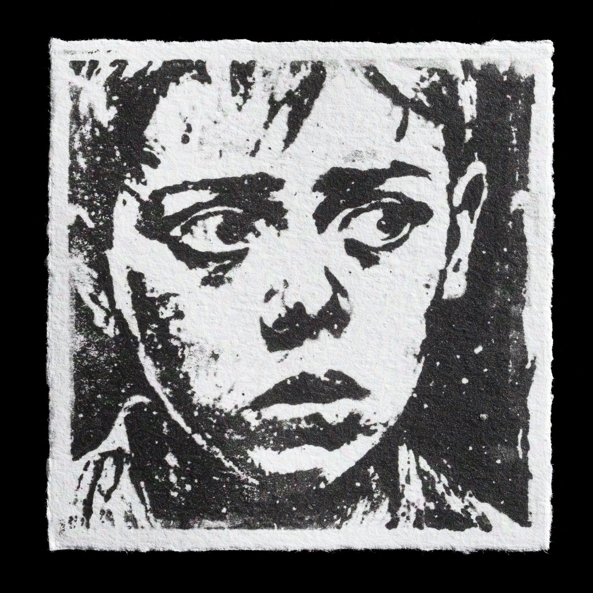 Here is a neutral, factual, and objective description of this image:

This monochromatic print titled 'War' by Uni Kateo features a somber face with furrowed brows and dark eyes, rendered in bold black lines on a white background. The photopolymer technique creates a textured effect, adding depth to the artwork.