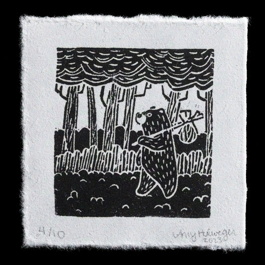 This linocut print, "The Wanderer" by Amy Holweger, showcases a serene forest scene with trees and foliage. The monochromatic color palette features a range of grays, creating a subtle contrast between the different elements.