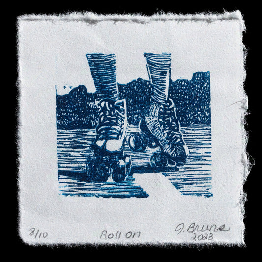 This linocut print, titled 'Roll On' by Jody L Bruns, features a blue-toned image of two people roller skating on a body of water. The dark background with lighter highlights creates a serene atmosphere, while the roller skaters add a sense of movement and energy to the scene.