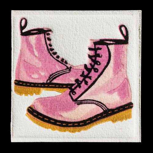 This print by Margo Born showcases a whimsical take on Dr. Martens boots, rendered in a vibrant pink hue with black laces and tan soles. The linocut technique brings out the intricate details of the footwear, set against a crisp white background.