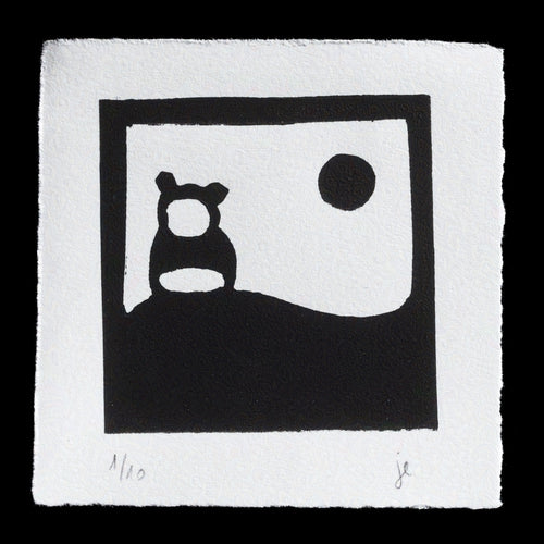 The image depicts a black-and-white linocut print titled 'Nevertheless' by Jacqueline Eskandari. The artwork features a simple yet striking design, with a bear-like creature situated in front of a landscape that includes a circle representing the sun or moon. The piece is signed and numbered at the bottom, indicating its edition status.