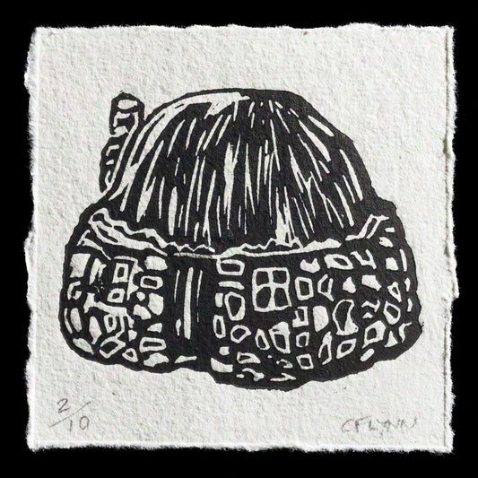This linocut print, titled 'Croft' by Cath Flynn, features a detailed black-and-white illustration of a small cottage with a thatched roof and stone walls. The print showcases intricate textures and patterns characteristic of traditional Scottish architecture.