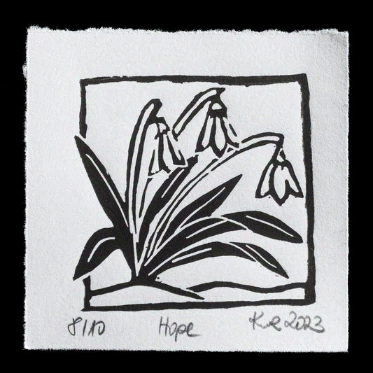 This captivating linocut print, "Hope" by kwr_handmade, showcases a delicate arrangement of three bell-shaped flowers with long stems, their petals elegantly curled inwards, set against a backdrop of lush green leaves and grasses. The artist's bold use of black ink creates striking contrast on the white background, evoking a sense of simplicity and serenity.