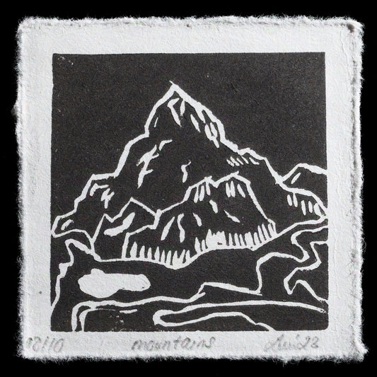 The Mountains is a captivating linocut print by Annemarie Luu, showcasing her skill in relief printing techniques. This artwork features:

� A serene landscape with majestic mountains
� Soothing color palette

This piece invites viewers to appreciate the beauty of nature, as captured through Luu's artistic lens.